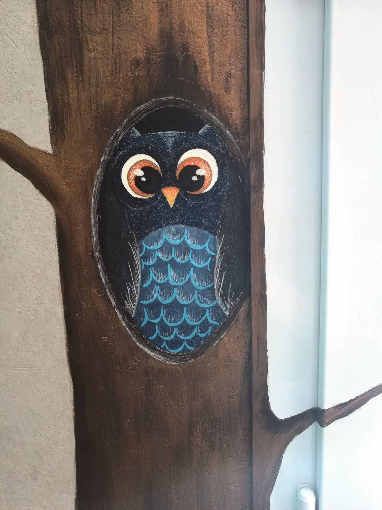 Détail d'un hibou peint dans un tronc